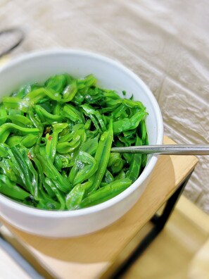 A bowl of green vegetables with a spoon. - Hanting Hotel (shanghai New International Expo Cen (Shanghai)