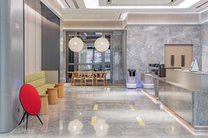 A modern lobby with a seating area, a reception desk, and a coffee machine. - Ji Hotel (Tianjin)