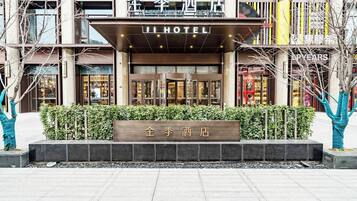 A hotel entrance with a sign reading 'JI HOTEL' and a nameplate in front.