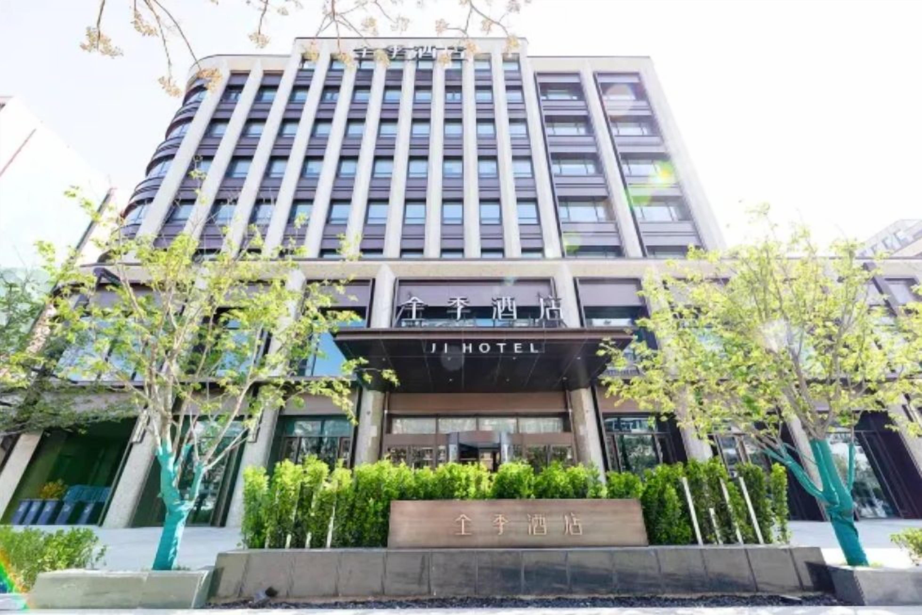 Un hotel con fachada moderna, varios pisos y una entrada destacada.