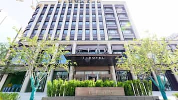 Un hotel con fachada moderna, varios pisos y una entrada destacada.