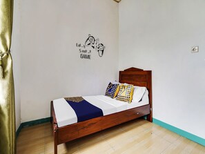 A single bed with a wooden frame, white bedding, and patterned pillows. - OYO 91128 Desa Wisata Lebakmuncang Ciwidey Syariah (Ciwidey)