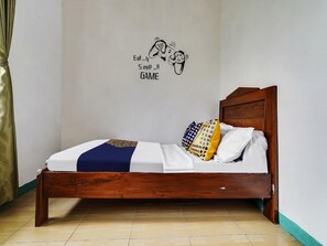 A single bed with a wooden headboard, white bedding, and patterned pillows. - OYO 91128 Desa Wisata Lebakmuncang Ciwidey Syariah (Ciwidey)