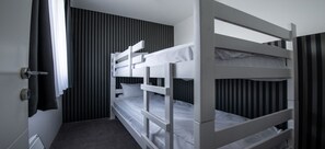 A bunk bed room with a door, a radiator, and striped curtains. - Hotel Djina (Raška)