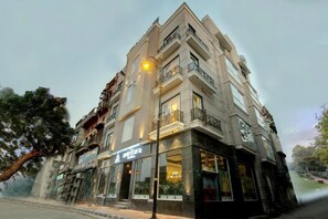 A multi-story hotel with balconies, large windows, and a sign for 'Hotel Amrita.' - Amritara Sadka, Amritsar Golden Temple (Amritsar)