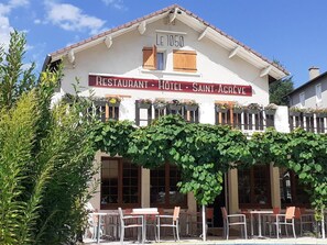 A building labeled 'LE 1050 RESTAURANT HOTEL SAINT-AGREVE' with outdoor seating and a vine-covered facade. - Logis Hotel le 1050 (Saint-Jeure-d'Andaure)
