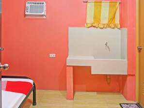 Une petite salle de bain avec un lavabo, un porte-serviettes et une prise de courant.