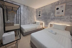 Ein Hotelzimmer mit zwei Betten, einem Spiegel, einem Nachttisch und einem Wandbild.