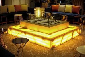 A modern living area with a glass-top coffee table, sofas with cushions, and a patterned floor. - Oriental Palace (Taza)