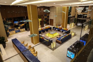 A modern lobby with a seating area, a reception desk, and a decorative wall with a geometric pattern. - Oriental Palace (Taza)