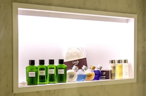 A shelf with various personal care products including shampoos, conditioners, and body lotions. - Oriental Palace (Taza)