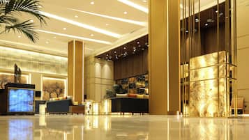 Eine moderne Lobby mit Empfangstresen, Sitzgelegenheiten und dekorativen Elementen.