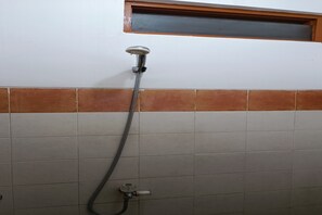 A shower with a handheld hose, a window above it, and a tiled wall with a brown horizontal accent. - OYO 91341 D'phoenix Anggrek Syariah Residence (Jakarta)