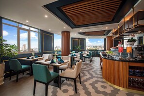 Ein modernes Restaurant mit Bar, großen Fenstern und Blick auf die Stadt.