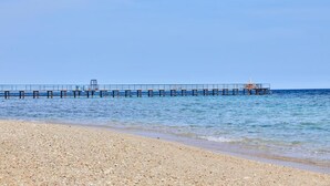A beach with a pier extending into the water.