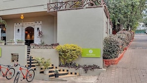 A building with a reception sign, a staircase, and bicycles parked in front. - Club Mahindra Saj Mahabaleshwar (Mahabaleshwar)