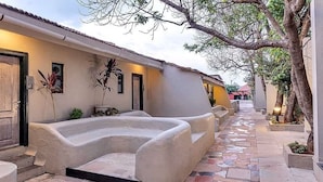A courtyard with a curved bench, a door, and a tiled pathway. - Club Mahindra Saj Mahabaleshwar (Mahabaleshwar)