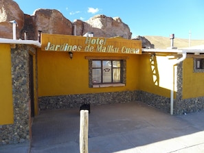 A yellow building with a sign reading 'Hotel Jardines de Malka Cuervo.' - Hotel Jardines de Mallku Cueva (Colcha K)