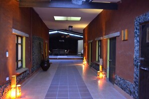 A corridor with tiled flooring, walls with textured patterns, and recessed lighting.