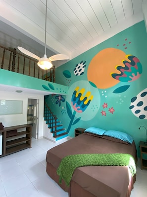 A bedroom with a bed, a staircase, a wall with abstract art, and a ceiling fan. - Casajomo (Rio de Janeiro)