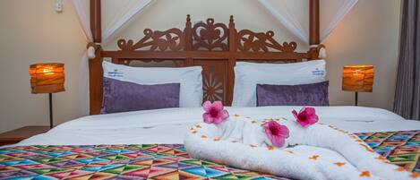 A bed with a geometric patterned bedspread, a wooden headboard, and two bedside lamps.