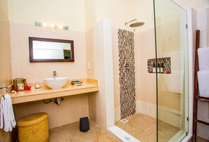 A bathroom with a sink, mirror, shower, and glass-enclosed shower stall. - Mzima Beach Resort (Diani Beach)