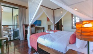 A hotel room with a bed, a desk, a chair, and a television. - Mzima Beach Resort (Diani Beach)