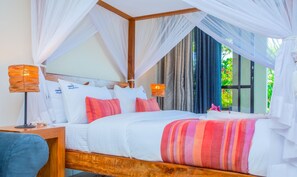 A bed with white bedding, a canopy, and a bedside table with a lamp. - Mzima Beach Resort (Diani Beach)