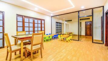 A room with a wooden table and chairs, a large window with a view, and a sliding glass door.