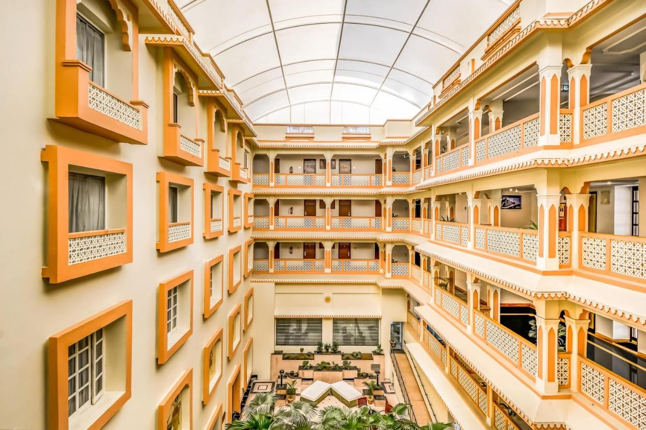 Un atrio de varios niveles con balcones, un patio central y un techo de cristal.