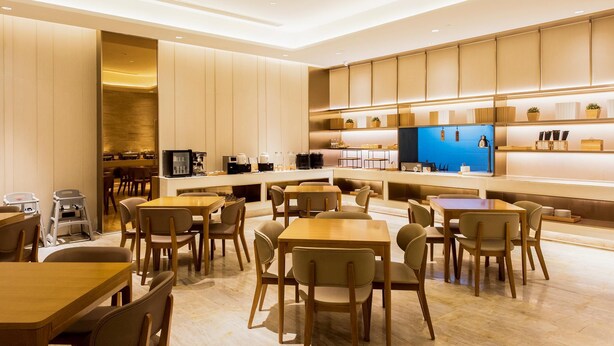 A modern hotel lobby with a central seating area, a reception desk, and a kitchen area. - JI Hotel Chongqin Liangjiang Xingfu Plaza (Chongqing)