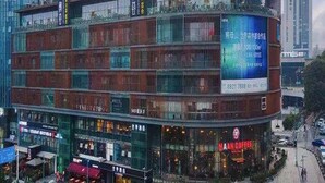A multi-story commercial building with a prominent sign for 'MAN COFFEE' on the ground floor. - JI Hotel Chongqin Liangjiang Xingfu Plaza (Chongqing)