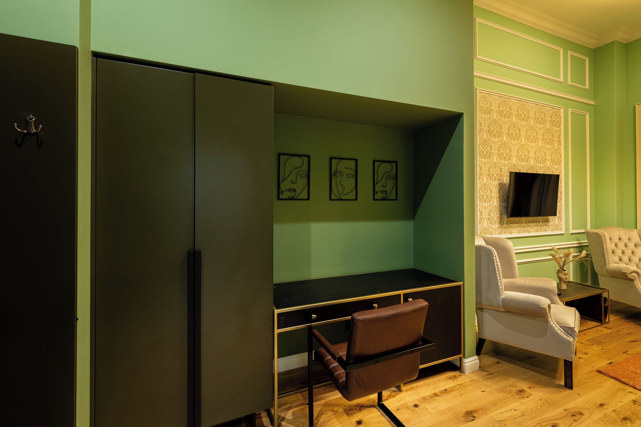 Una habitación con escritorio, silla, televisor y armario.