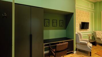 Una habitación con escritorio, silla, televisor y armario.