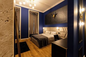 Un dormitorio con cama, mesita de noche y una obra de arte colgada con la imagen de una cabeza de toro.