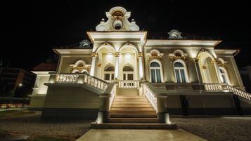 A grand building with a central staircase, multiple arches, and a prominent entrance.