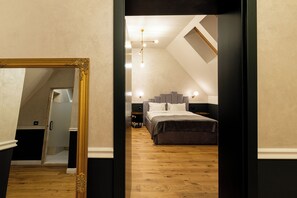 A bedroom with a large mirror, a bed, a nightstand, and a ceiling light fixture.