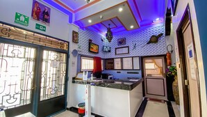 A reception area with a counter, a clock, framed pictures, and a fire extinguisher.