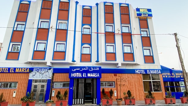 A hotel with a blue and orange facade, multiple windows, and a sign indicating it is a hotel.