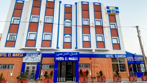 A hotel with a blue and orange facade, multiple windows, and a sign indicating it is a hotel. - Hotel El Marsa La Playa (El Marsa)