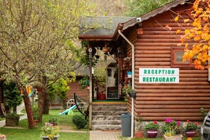 A wooden cabin with a reception area and a sign indicating it's a restaurant.