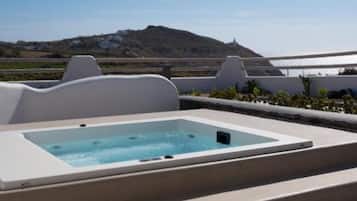 Um terraço no telhado com hidromassagem, área de estar externa e vista para a costa.