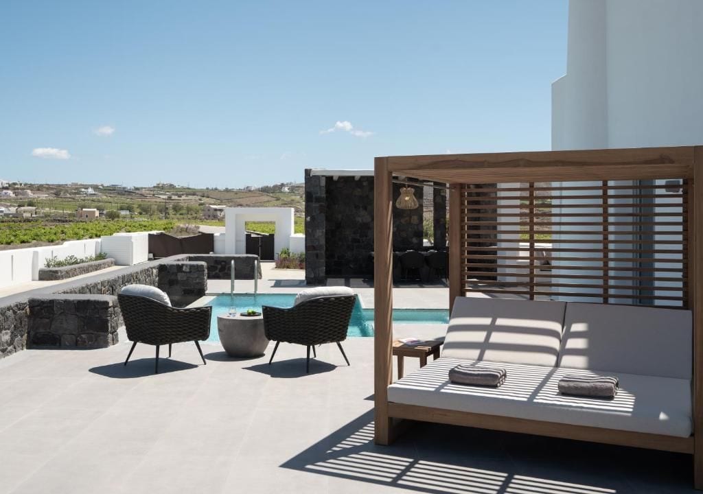 A rooftop terrace with a pool, outdoor seating, and a view of the landscape.