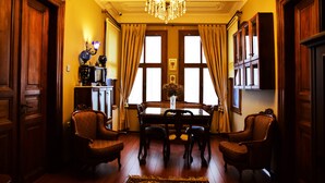 A dining room with a chandelier, wooden furniture, and large windows with curtains. - Ottoman Suites By Sera House (Istanbul)