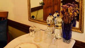 A table with a mirror, a framed certificate, and a vase with dried flowers. - Ottoman Suites By Sera House (Istanbul)