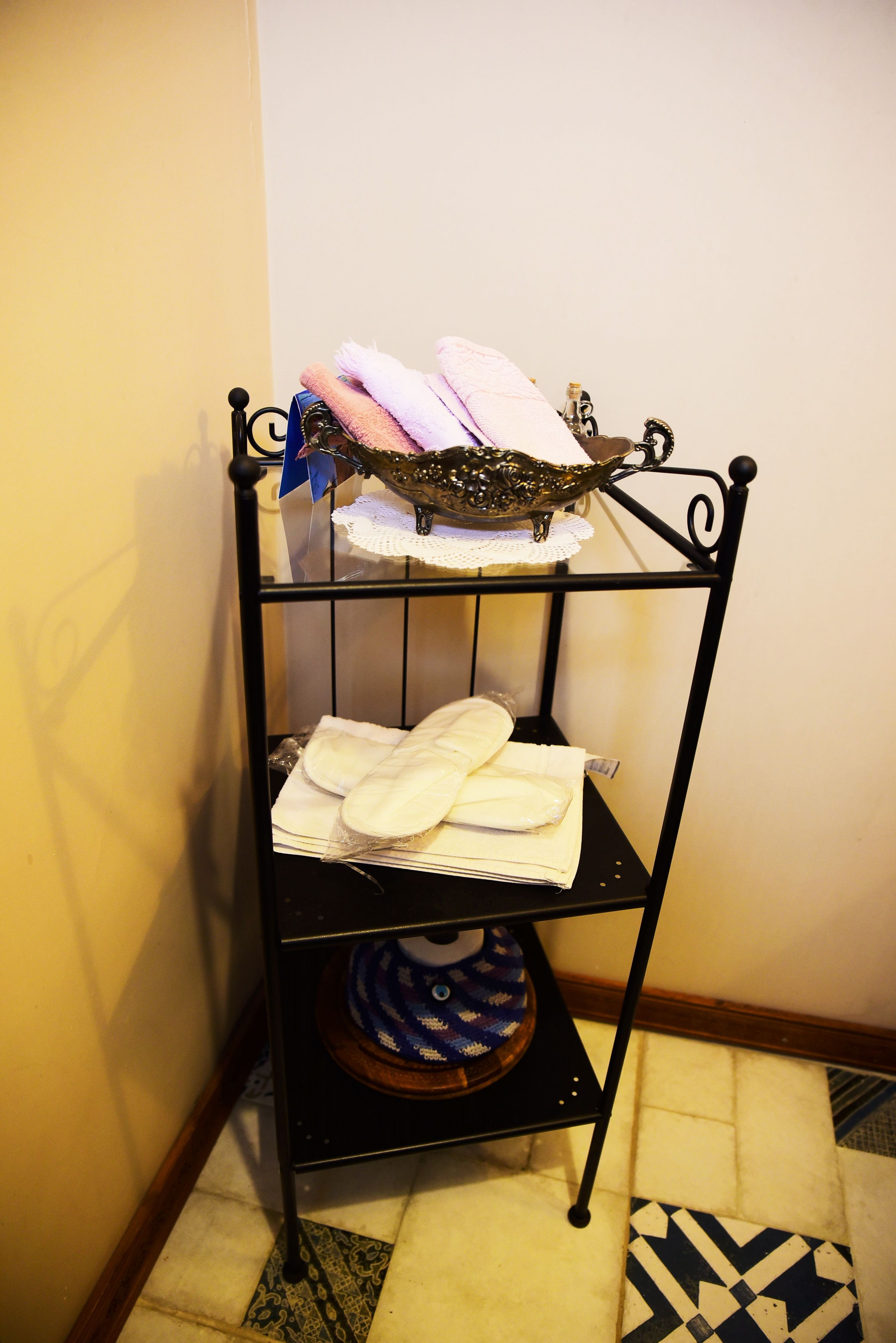 A corner shelf with folded towels and a decorative item.
