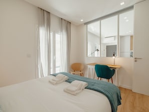 A hotel room with a bed, a desk, a chair, and a large mirror. - Apartment  by Interhome (Porto)