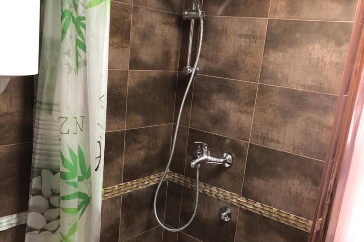 Un espace douche équipé d’un pommeau de douche, d’un pommeau de douche à main et d’un robinet mural.
