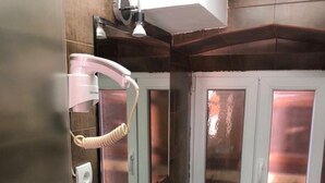 Un baño con lavamanos, espejo y dos armarios.