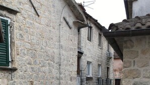 Un estrecho callejón adoquinado entre edificios, con puertas en arco y una pequeña escalera.